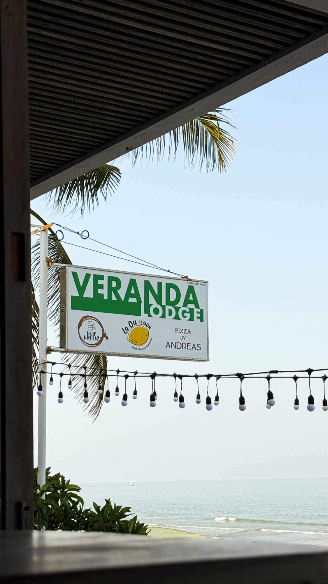 Veranda Lodge sign with Pizza by Andreas, above the beach